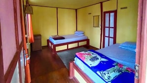 Ein Zimmer mit einem Bett, einem Nachttisch, einem Kleiderschrank und einer Tür.