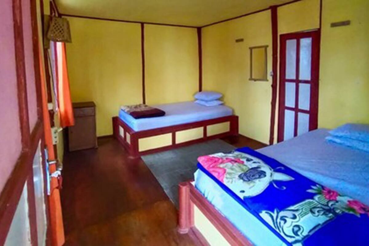 Una stanza con un letto, un comodino, un armadio e una porta.