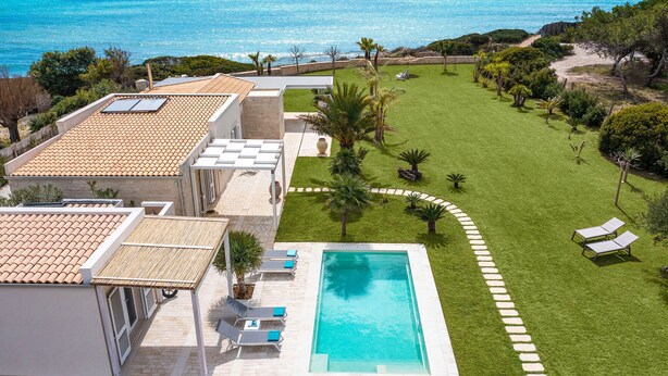 A rooftop terrace with a swimming pool, a well-maintained lawn, and a view of the sea. - Luxury villa with pool, beach front, Porto Ulisse (Ispica)