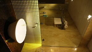 A bathroom with a tiled wall, a sink, a mirror, and a towel rack. - Silver Paradise (Navi Mumbai)