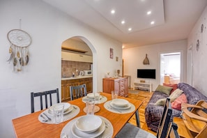 A modern living space with a dining area, kitchen, and a cozy seating area.