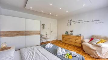 Ein modernes Schlafzimmer mit einem Bett, einem Sessel, einer Kommode und einer Wand mit motivierendem Text.