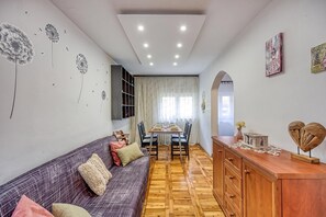 Un salon moderne avec un canapé, une table à manger et des meubles en bois.