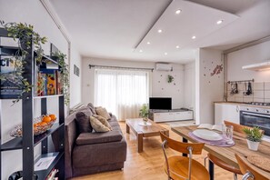 Un espace de vie moderne comprenant un canapé, une table à manger et un coin cuisine.