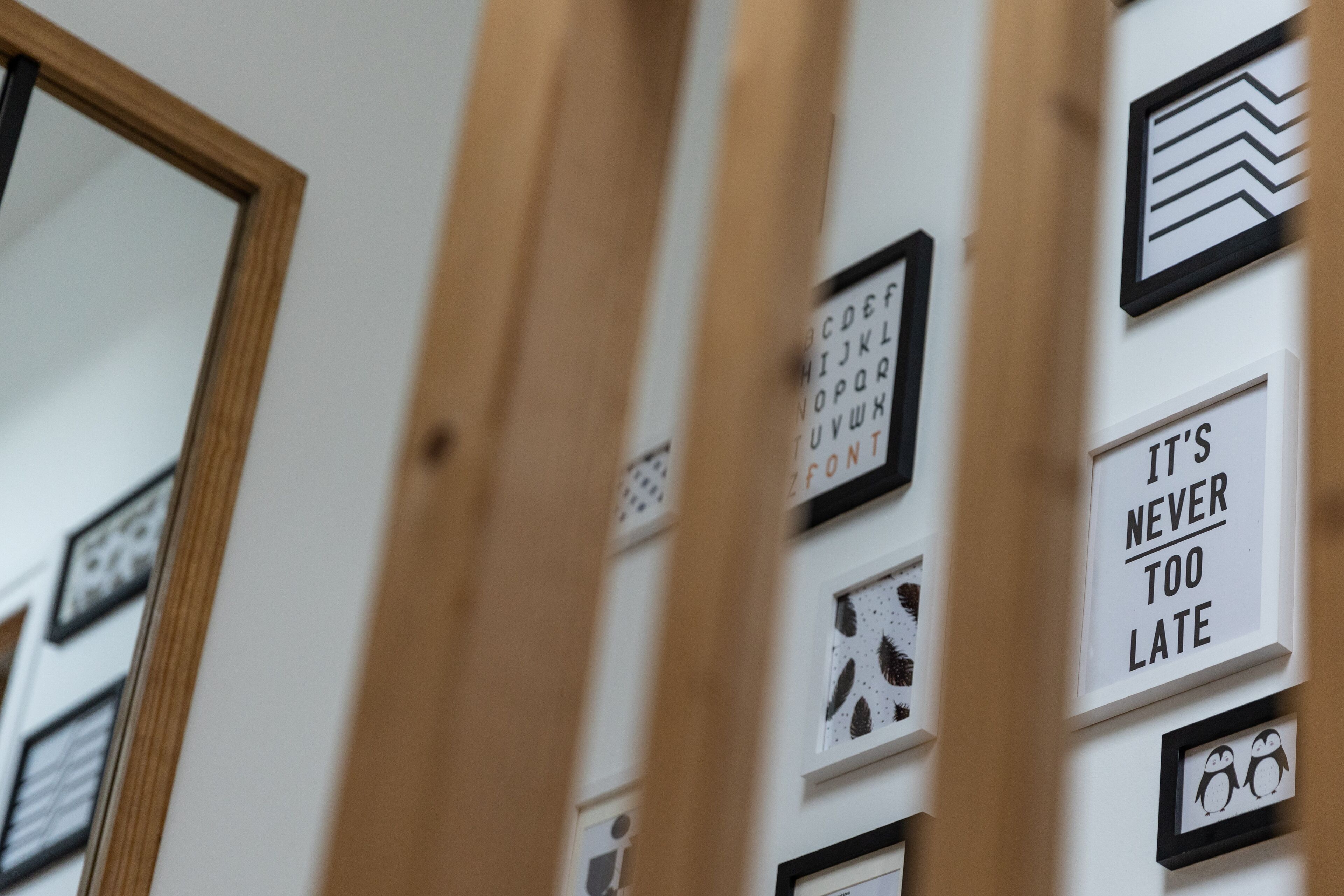 Pared con cuadros que incluyen una tabla de visión, letras del alfabeto y una frase motivacional.