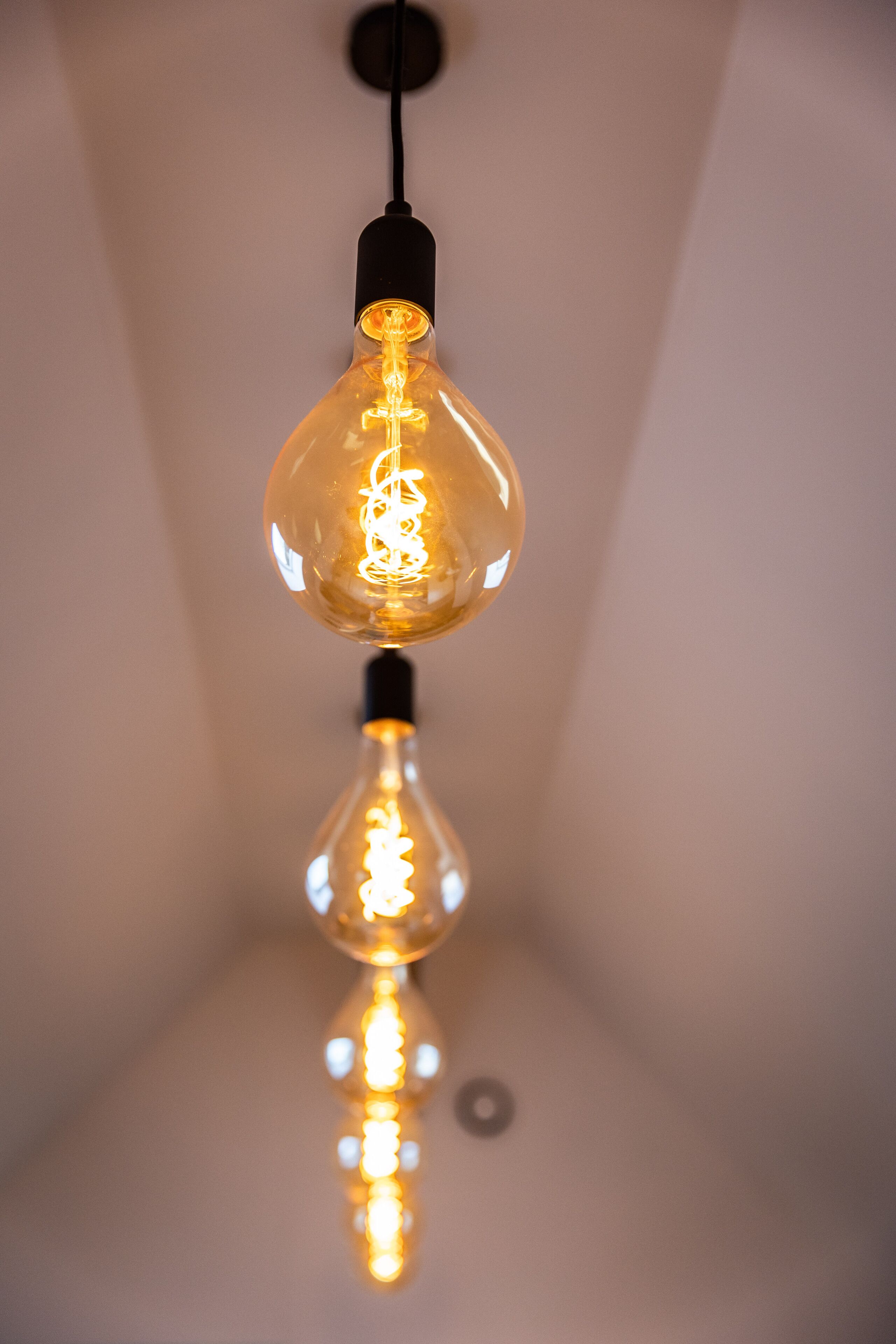 Due lampadine a sospensione con filamento a vista.