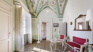 A room with a patterned floor, white furniture, and a decorative ceiling.
