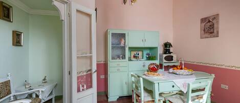 Una cocina acogedora con una mesa de comedor, sillas y un armario.