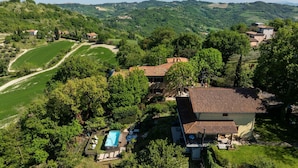 Eine Villa mit Swimmingpool, umgeben von üppiger Vegetation und Hügeln.
