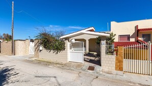 A residential street with houses, a gated entrance, and a clear blue sky. - 3266 Villetta Delle Viole by Barbarhouse (Torricella)