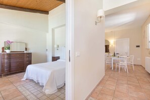 A bedroom with a bed, dresser, and a bathroom visible through an open door. - 3270 Dependance di Omero by Barbarhouse (Cavallino)