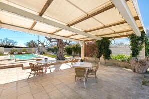 A covered patio area with outdoor furniture, a swimming pool, and a large tree. - 3270 Dependance di Omero by Barbarhouse (Cavallino)