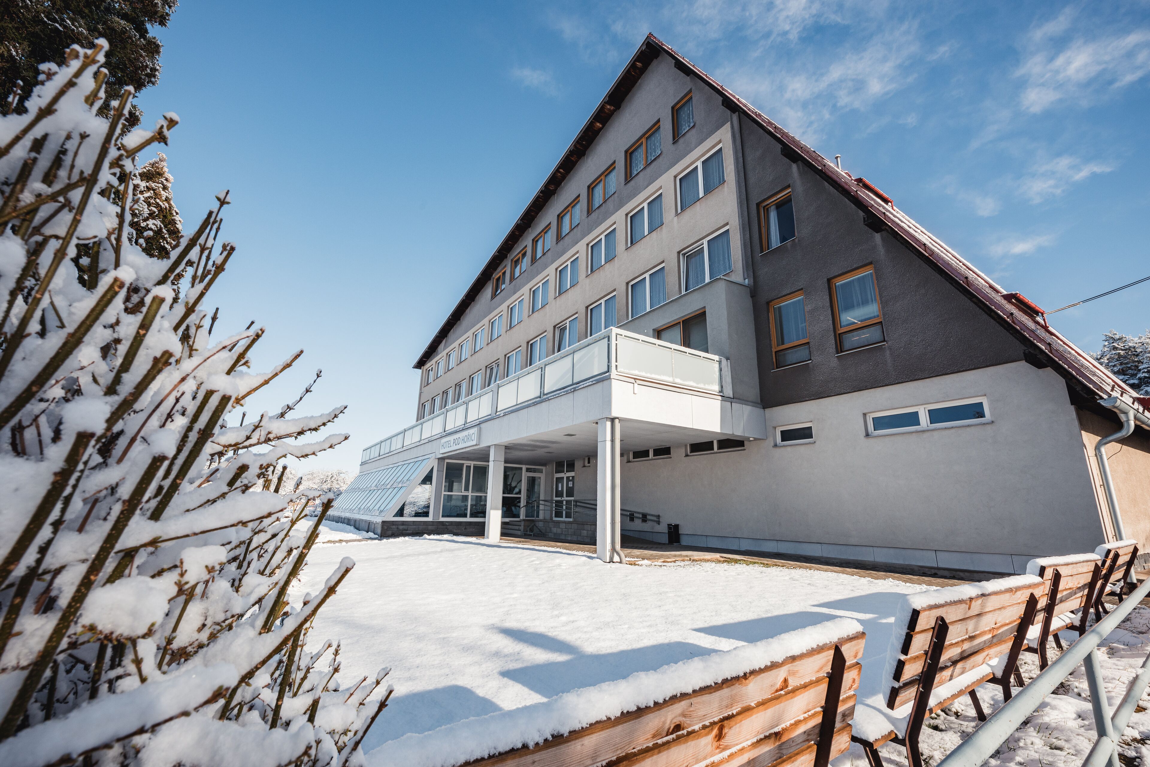 A hotel with a modern architectural design, featuring a covered entrance and multiple windows.