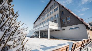 A hotel with a modern architectural design, featuring a covered entrance and multiple windows.