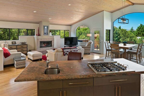 A spacious living area with a fireplace, a TV, and a dining area with a view.
