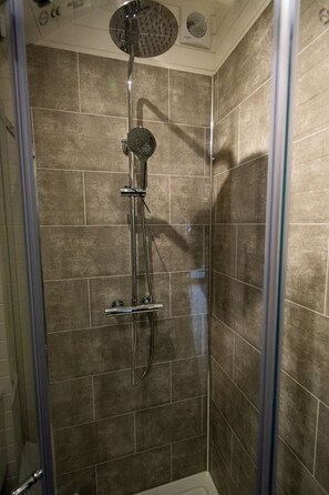 A shower with a handheld showerhead and a wall-mounted faucet. - Beech Pod Cabin in Beautiful Surroundings Wrexham (Wrexham)