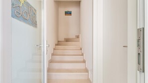 A staircase leading to a landing with a small framed picture on the wall. - 3274 Residence Amida - Appartamento Sole by Barbarhouse (Maruggio)