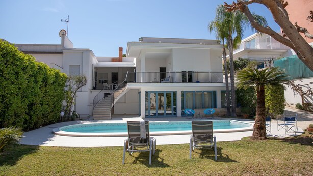A modern two-story house with a swimming pool, outdoor seating, and a staircase leading to a balcony. - Villa Ravanica (Giannuzza) with pool 400m from the beach (Marina di Ragusa)