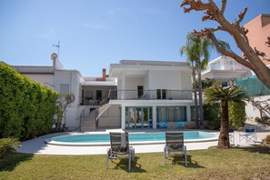 A modern two-story house with a swimming pool, outdoor seating, and a staircase leading to a balcony. - Villa Ravanica (Giannuzza) with pool 400m from the beach (Marina di Ragusa)