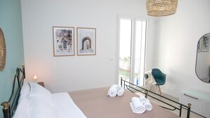 A neatly made bed with white and brown linens, a bedside lamp, and two framed pictures on the wall. - Villa Ravanica (Giannuzza) with pool 400m from the beach (Marina di Ragusa)