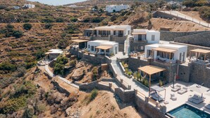A hillside property with multiple white buildings, a swimming pool, and outdoor seating areas. - Sigma Residences Boutique Hotel (Sifnos)