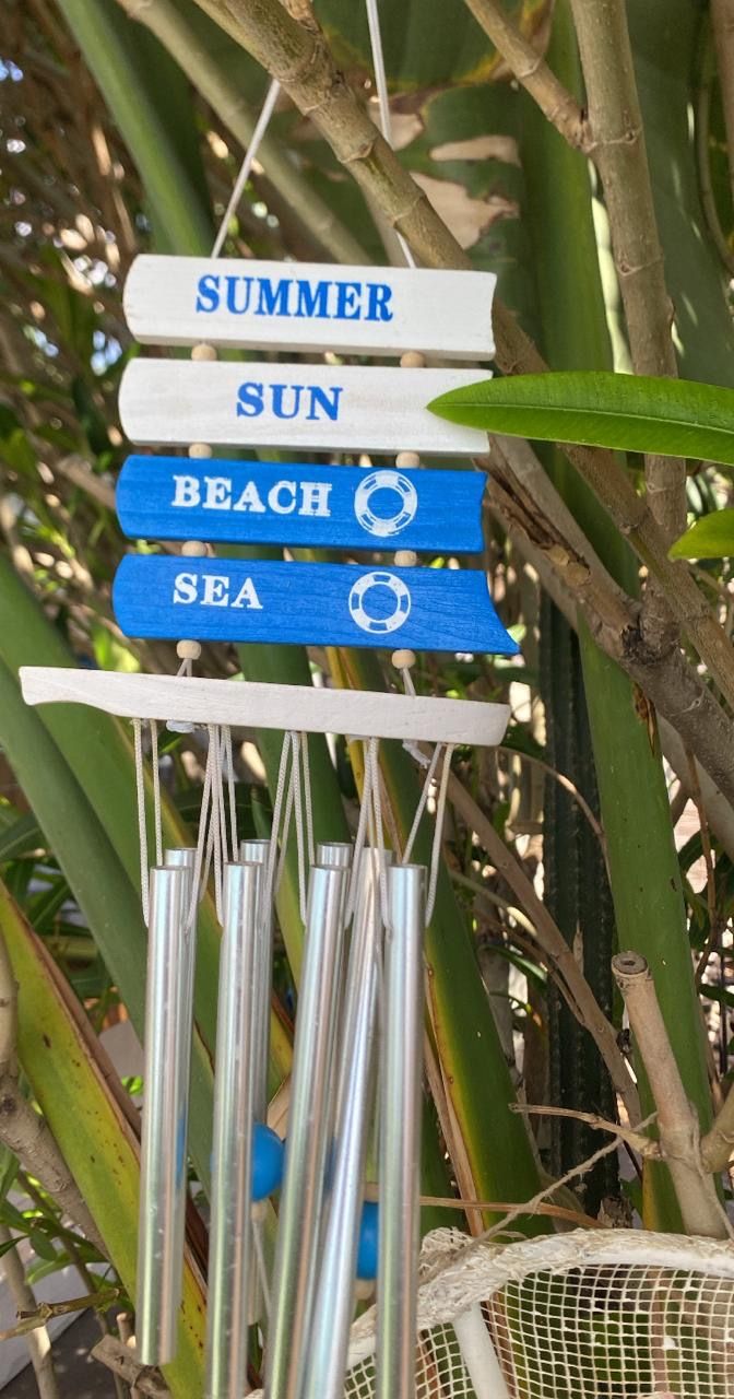 A sign with words 'SUMMER', 'SUN', 'BEACH', and 'SEA' hanging from a structure.