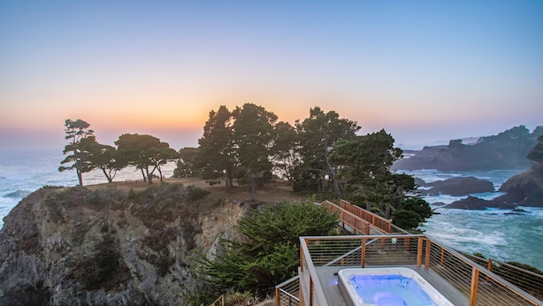A hot tub on a wooden deck overlooking a rocky coastline with trees and ocean views. - Buckhorn Cove Ocean Front with Private Peninsula (Little River)