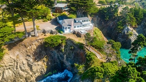 A coastal property with a large house overlooking a rocky cliff and turquoise waters. - Buckhorn Cove Ocean Front with Private Peninsula (Little River)