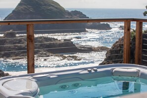 Un bain à remous avec vue sur l’océan et les falaises rocheuses.