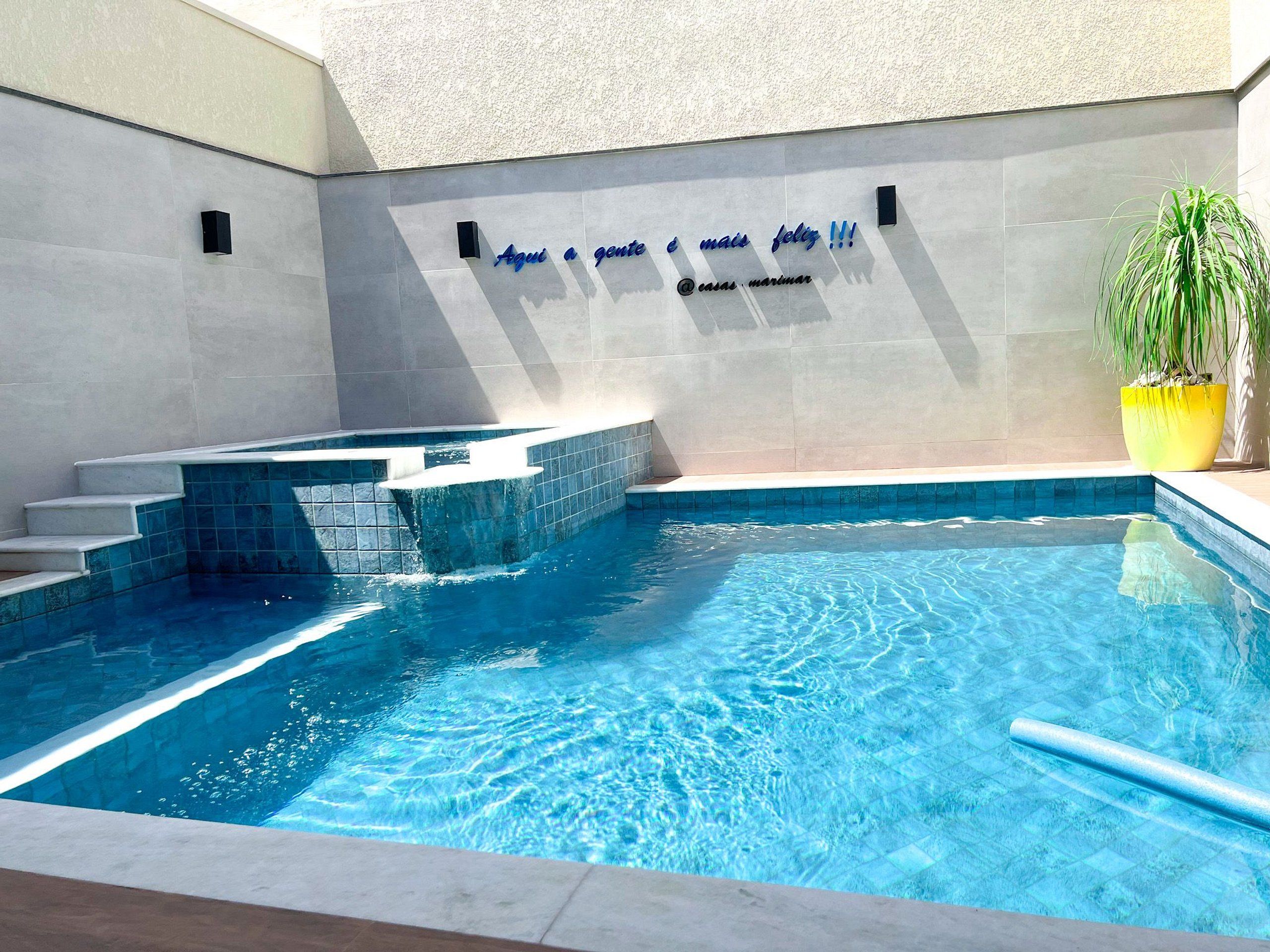 Una piscina con borde de azulejos y una pequeña cascada.