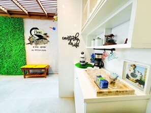 Una cocina moderna con una pared verde, un banco de madera y una estación de café.