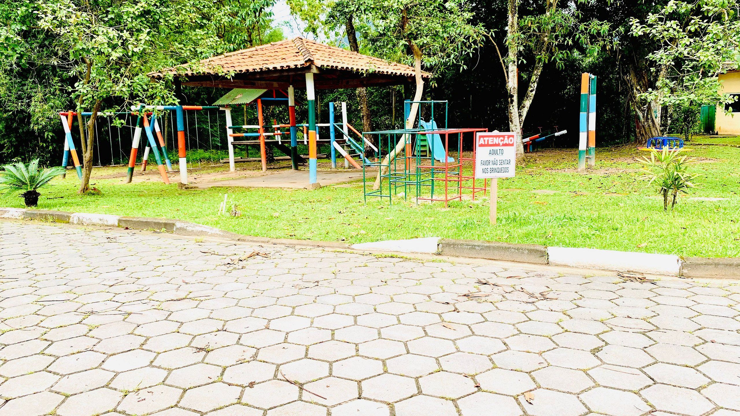 Um parquinho com um gazebo e balanços.