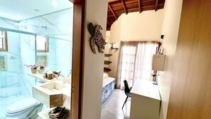 Un baño con lavamanos de mármol, inodoro y zona de ducha.