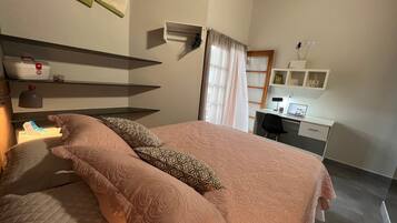 Un dormitorio con cama, escritorio, silla y estante con botiquín.