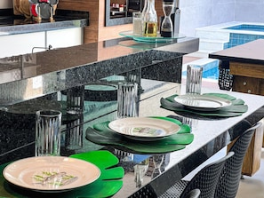 Een moderne keuken met een granieten aanrechtblad, groene placemats en een vis op een bord.