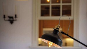 En matplats med ett bord, stolar och en hängande lampa.