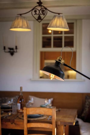 Un espace repas comprenant une table, des chaises et une lampe suspendue.
