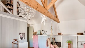 A bedroom with a bed, a hanging chair, a desk, and a bookshelf. - Stunning 4* Home for 6, Beach & Port Walkable (Le Guilvinec)
