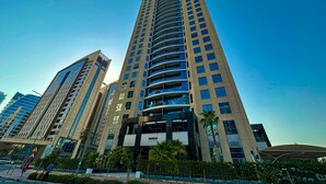 A high-rise building with multiple floors, large windows, and a modern architectural design. - HiGuests - Madison Residency (Dubai)