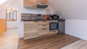 Een moderne keuken met houten kastjes, een inbouwoven en een magnetron.