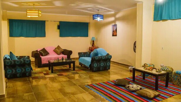 A living room with two sofas, a coffee table, and a patterned rug. - Jamila basement apartment (New Cairo)