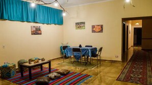 A dining area with a table set for two, a patterned rug, and a blue curtain. - Jamila basement apartment (New Cairo)