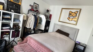 Un dormitorio con cama, armario, escritorio y techo decorado con un mural de grafiti.