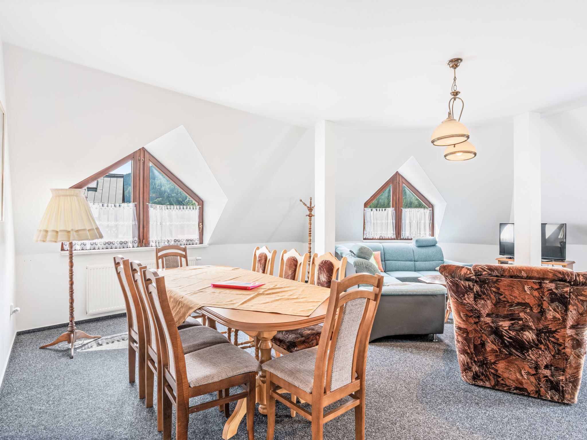 Une chambre moderne de style loft, comprenant un coin repas, un canapé et un téléviseur.