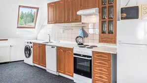 A modern kitchen with wooden cabinets, a built-in oven, a dishwasher, and a microwave. - Harrachov Lookout by Interhome (Harrachov)