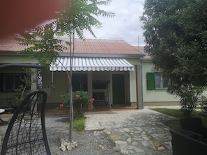 A house with a tiled roof, a covered porch, and a stone pathway leading to the entrance. - Moja Ane (Razanac)