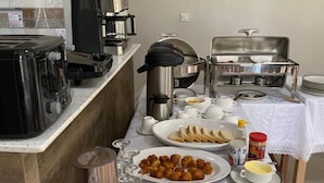 Un bufé de desayuno con diversos alimentos y electrodomésticos de cocina.
