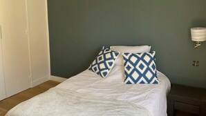 Ein Schlafzimmer mit einem Bett, einem Nachttisch, einer Klimaanlage und einer Wandlampe.