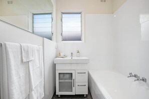 Bathtub, hair dryer, towels, shampoo