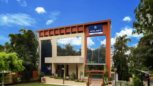 Un moderno edificio de hotel con un letrero llamativo que dice "HOTEL AKETA DEHRADUN".